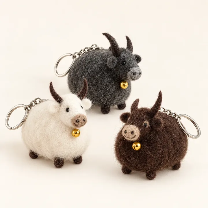 AI studio recreation of three wool felt yak keychains with tiny bells