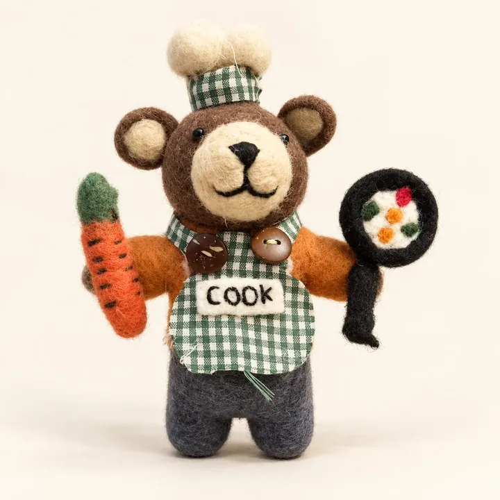 AI studio recreation: Handmade chef bear with a gingham apron, carrot and frying pan